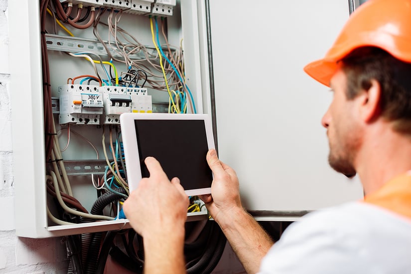 Hardhat worker using tablet at power station